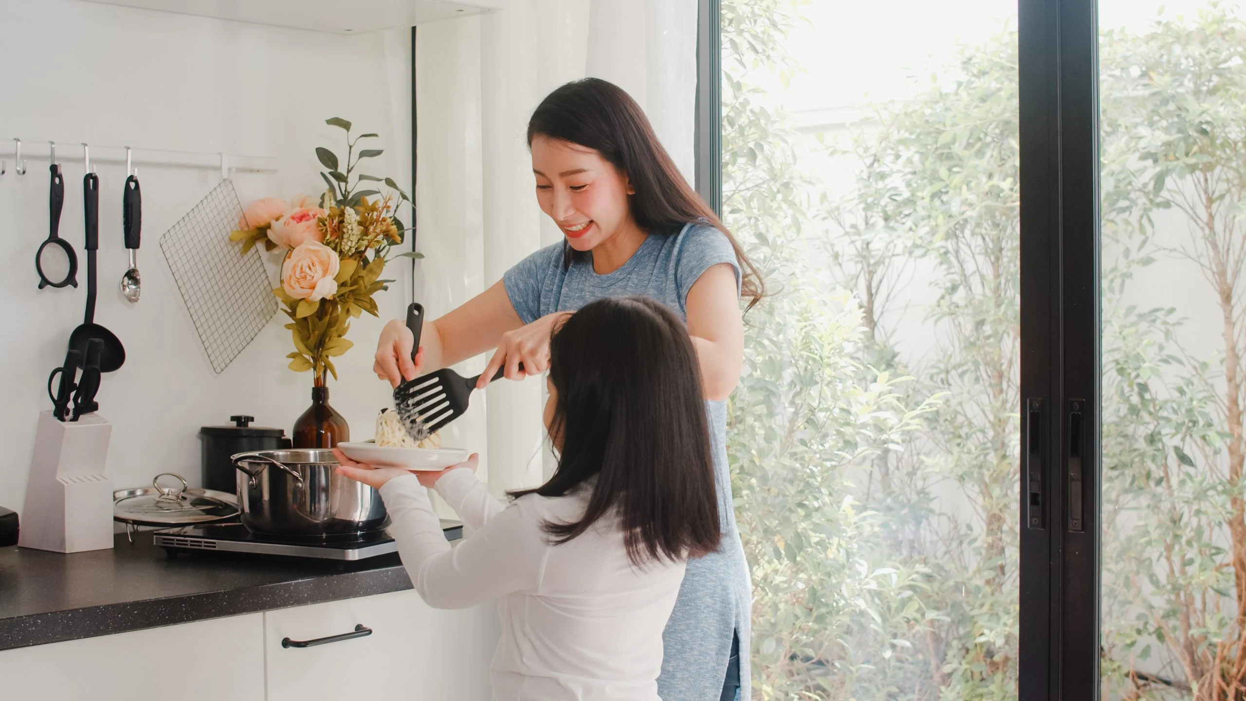 Young Asian Japanese Mom and Daughter cooking at home. Lifestyle Melbourne disability services